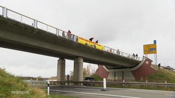 Auf einer Autobahnbrücke haben Aktivisten ein Banner angebracht. © Screenshot 