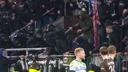 Polizisten und Fans geraten aneinander, vorne stehen Spieler auf dem Feld © Screenshot 