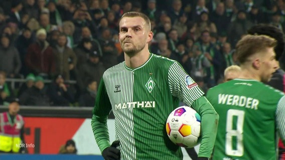 Marvin Ducksch vom SV Werder Bremen steht mit dem Fußball unterm Arm auf dem Spielfeld. © Screenshot 