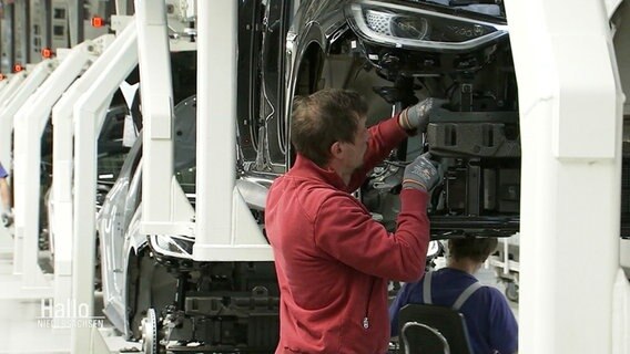 Mitarbeiter in der Werkhalle eines Autoherstellers. © Screenshot 