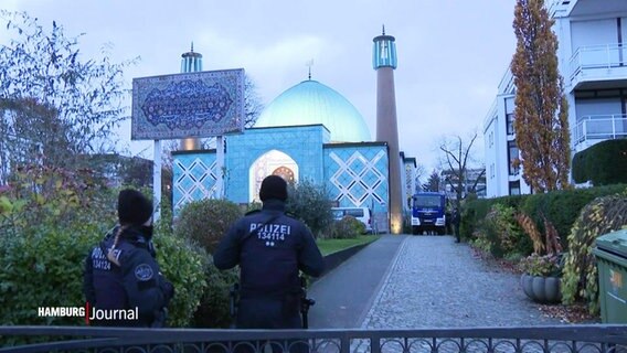 Zwei Polizisten stehen vor der blauen Moschee in Hamburg. © Screenshot 