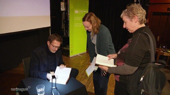Florian Illies signiert ein Buch. © Screenshot 