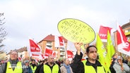 Menschen demonstrieren mit Protestplakaten. © Screenshot 