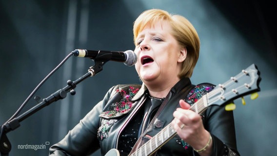 Ein KI-generiertes Foto: Angela Merkel als Rocksängerin mit Gitarre. © Screenshot 
