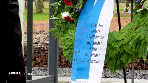 Ein Blumenkranz mit der Aufschrift "Euer Tod - unsere Verpflichtung. Nie wieder Krieg, nie wieder Faschismus" © Screenshot 
