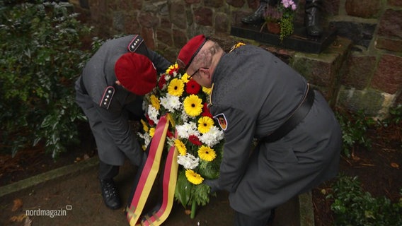 Zwei deutsche Soldaten legen einen Kranz einer Gedenkstätte für Opfer der beiden Weltkriege nieder. © Screenshot 