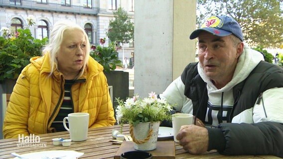 Zwei Personen an einem Tisch in einem Café. © Screenshot 