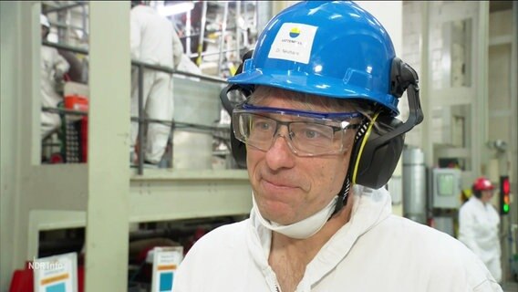 Technischer Geschäftsführer in Sicherheitsmontur spricht im Interview in einm Atomkraftwerk über den Abbau von radioaktiven Abfall in ein Endlager. © Screenshot 