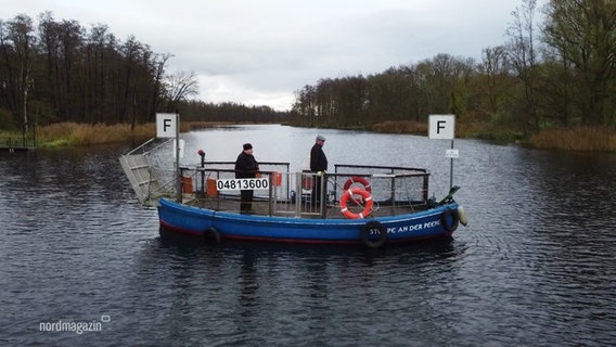 Zwei Menschen stehen auf der Peene-Fähre. © Screenshot 