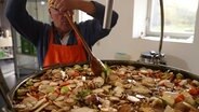 Koch setzt eine Brühe in einem großen Topf an. © Screenshot 