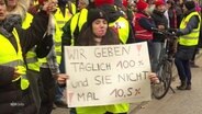 Protestierende mit Plakat. © Screenshot 