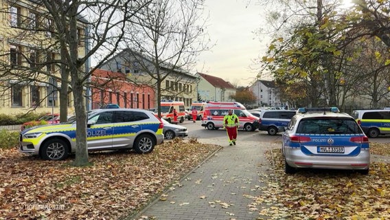 Mehrere Polizeiwagen und Rettungswagen stehen auf einem Platz. © Screenshot 