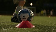 Ein Kind tritt auf einem Fussballplatz gegen einen Ball. © Screenshot 