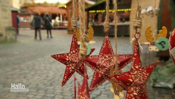 Weihnachtssterne an einem Stand auf einem Weihnachtsmarkt. © Screenshot 