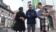 Drei Personen erkunden zusammen die Krimi-Tour durch Einbeck. © Screenshot 