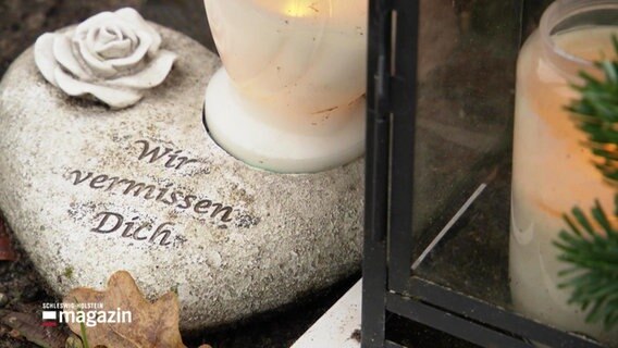 Auf einem Gedenkstein in Herz-Form steht "Wir vermissen dich". © Screenshot 