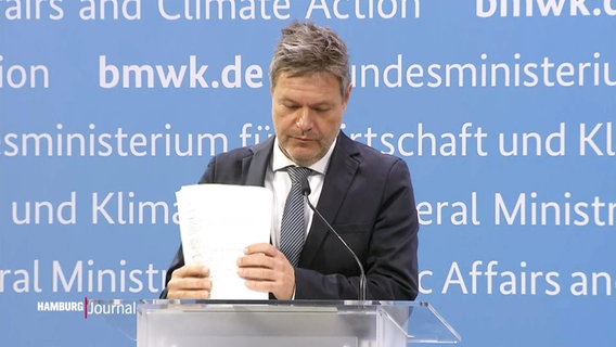 Bundeswirtschaftsminister Robert Habeck packt am Rednerpult seine Unterlagen zusammen. © Screenshot 