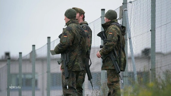 Soldaten stehen an einem Zaun. © Screenshot 