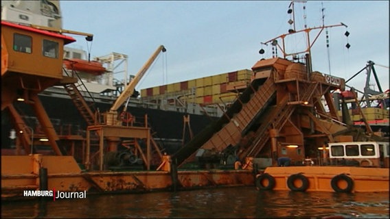 Eine Förderkonstruktion und Container in einem Hafenbecken. © Screenshot 