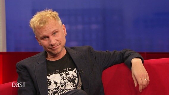 Robert Stadlober auf dem roten Sofa. © Screenshot 