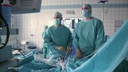 Zwei Ärzte operieren an einem Knie. © Screenshot 