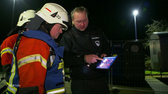 Feuerwehrmännern mit einem Tablet, das sie angucken. © Screenshot 
