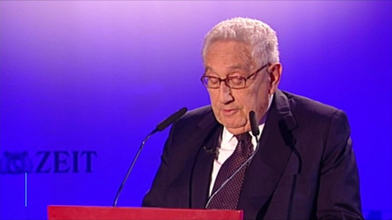 Henry Kissinger am Rednerpult. © Screenshot 