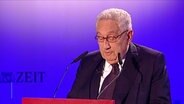 Henry Kissinger am Rednerpult. © Screenshot 