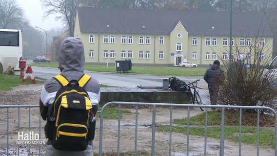 Person blickt mit Rücken zur Kamera gedreht auf die Geflüchtetenunterkunft Oerbke. © Screenshot 