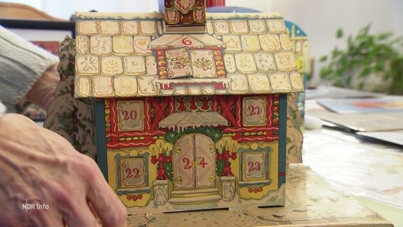 Ein historischer Adventskalender als kleines Häuschen aus Pappe. © Screenshot 