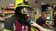 Eine Person der Feuerwehr mit Gasmaske. © Screenshot 