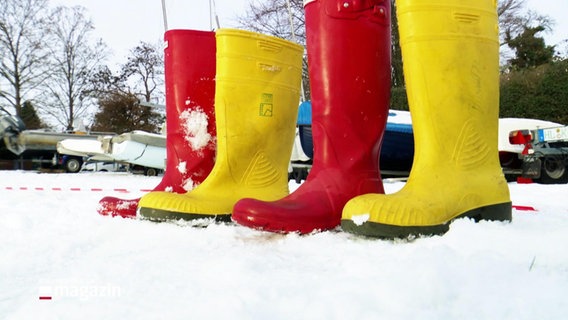 Vier Gummistiefel stehen nebeneinander im Schnee: Ein roter, ein gelber, ein roter, ein gelber. © Screenshot 