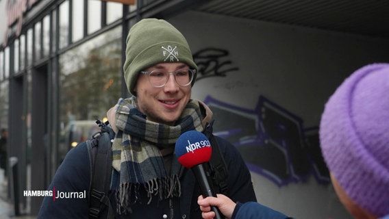 Reporterin Anne Adams spricht in Eimsbüttel mit einem jungen Mann namens Jonathan über sein Thema der Woche. © Screenshot 