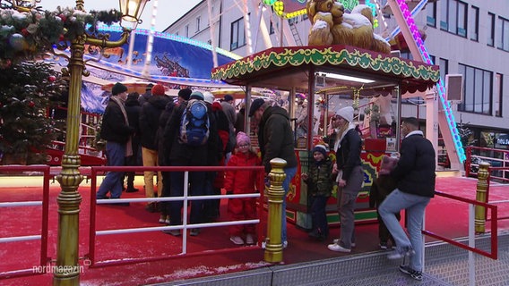 Mehrere Menschen stehen für ein Fahrgeschäft an. © Screenshot 