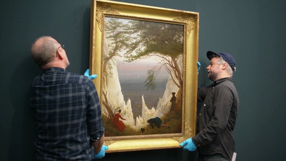 Zwei Mitarbeiter der Kunsthalle hängen das Bild "Kreidefelsen auf Rügen" auf. © Screenshot 