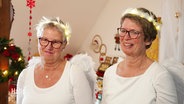 Ruth Meyer und Ingrid Kober aus der Kirchengemeinde Helstorf, in weiß gekleidet mit Lichterkette in den Haaren und weißen Federflügeln. © Screenshot 