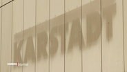 Ein verblichenes Karstadt-Logo ist an einer Kaufhauswand zu sehen. © Screenshot 