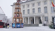 Auf dem verschneiten Marktplatz von Malchin steht eine Weihnachtspyramide. © Screenshot 