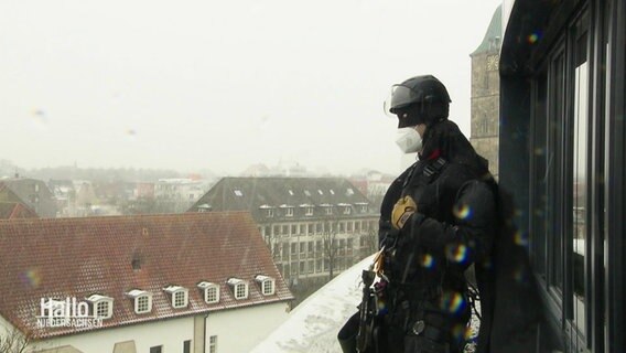 Ein als Batman verkleideter Mann steht auf einem Krankenhaus Dach. © Screenshot 