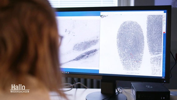 Eine Frau sitzt vor einem Computer Monitor, auf dem ein Fingerabdruck zu sehen ist. © Screenshot 