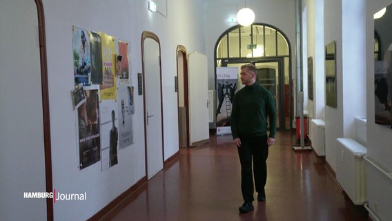 Ein junger Mann auf dem Flur im Gebäude der Hamburg Media School. © Screenshot 