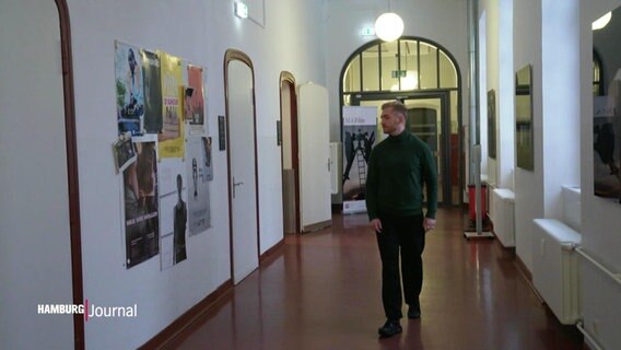 Ein junger Mann auf dem Flur im Gebäude der Hamburg Media School. © Screenshot 