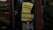 Ein ehrenamtlicher Helfer des Kältebus-Teams versorgt einen Obdachlosen. © Screenshot 