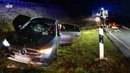 Ein Mercedes mit zerstörter Windschutzscheibe steht neben einer Straße. © Screenshot 