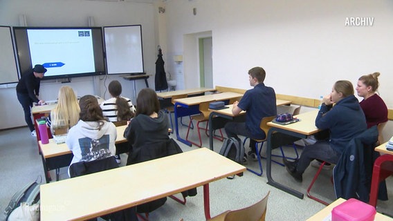 Schüler sitzen in einem Klassenzimmer. © Screenshot 