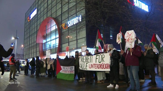 Demonstranten stehen vor einem Kaufhaus in Hamburg. © Screenshot 