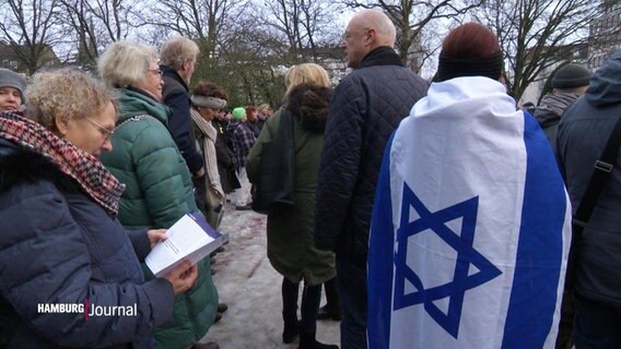 Auf einer Demonstration hat sich eine Teilnehmerin in die Flagge Israels gehüllt. © Screenshot 