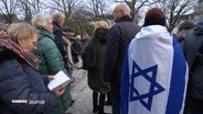 Auf einer Demonstration hat sich eine Teilnehmerin in die Flagge Israels gehüllt. © Screenshot 