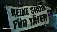 Ein Protestplakat mit der Aufschrift "Keine Show für Täter" am Rande eins Konzerts von Till Lindemann. © Screenshot 