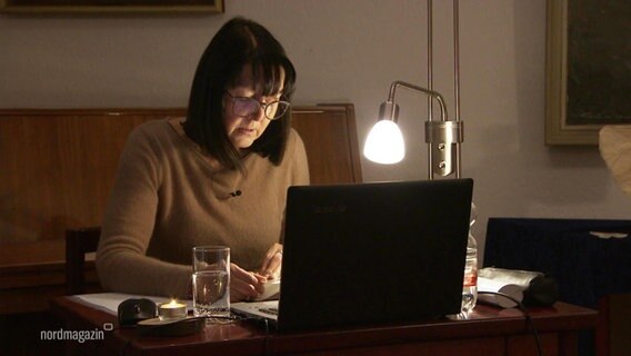 Eine Frau sitzt an einem Schreibtisch vor einem Laptop und liest. © Screenshot 